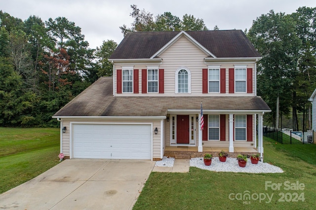 colonial home featuring a garage and a front lawn