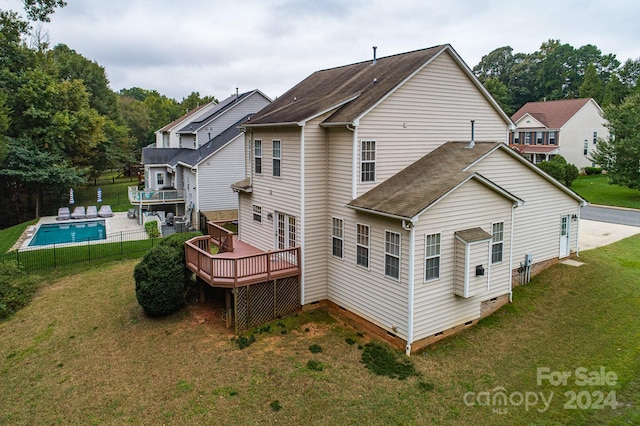 back of property featuring a lawn and a pool side deck