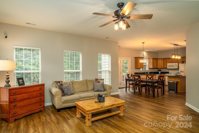 living room featuring ceiling fan, plenty of natural light, and dark hardwood / wood-style floors