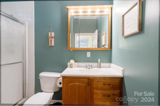 bathroom featuring vanity, toilet, and an enclosed shower