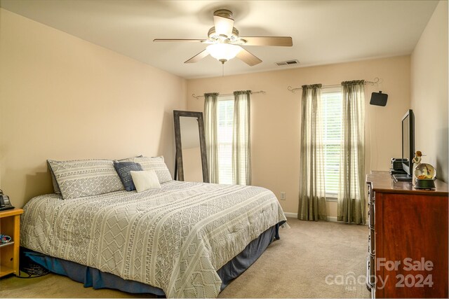 bedroom with ceiling fan and light colored carpet