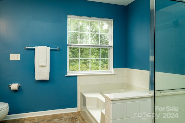 bathroom featuring a washtub and toilet