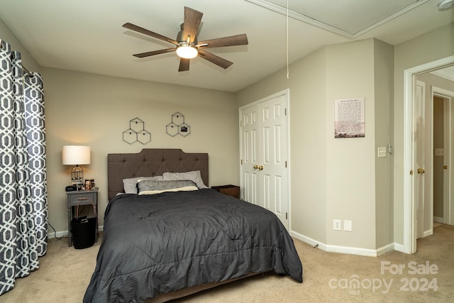 bedroom featuring light carpet, ceiling fan, and a closet