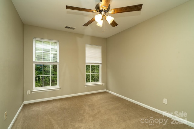 empty room with ceiling fan and light colored carpet