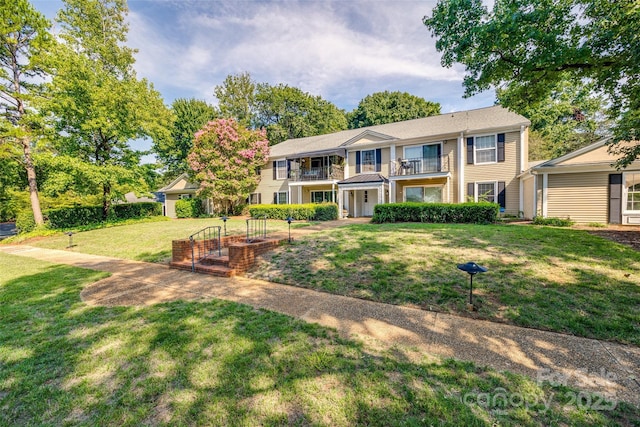 view of front of home with a balcony and a front yard