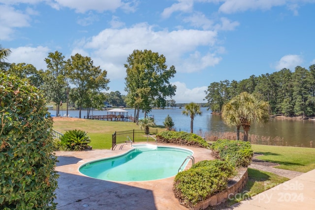 view of swimming pool with a lawn and a water view