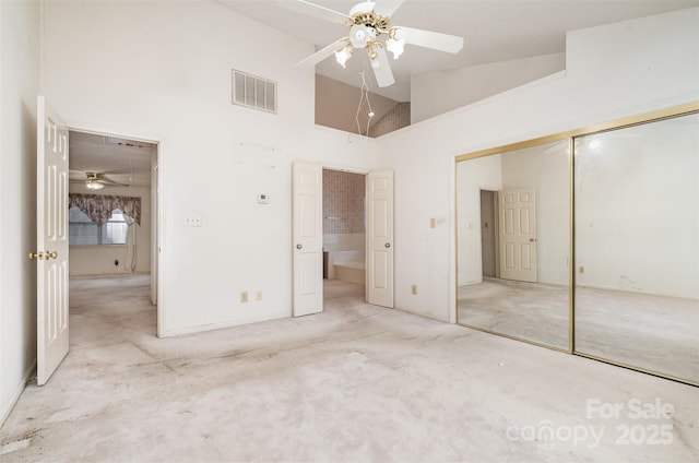 unfurnished bedroom featuring ceiling fan, a closet, and high vaulted ceiling