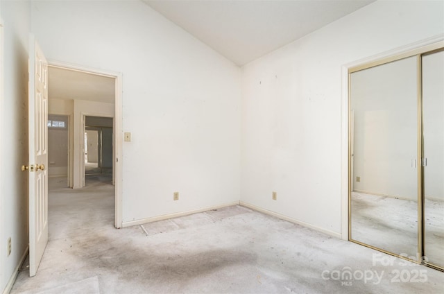 unfurnished bedroom featuring a closet and lofted ceiling