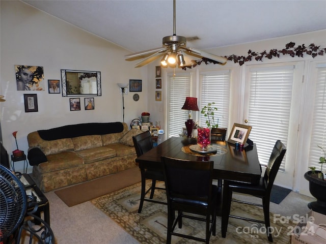 dining room with ceiling fan, vaulted ceiling, and carpet