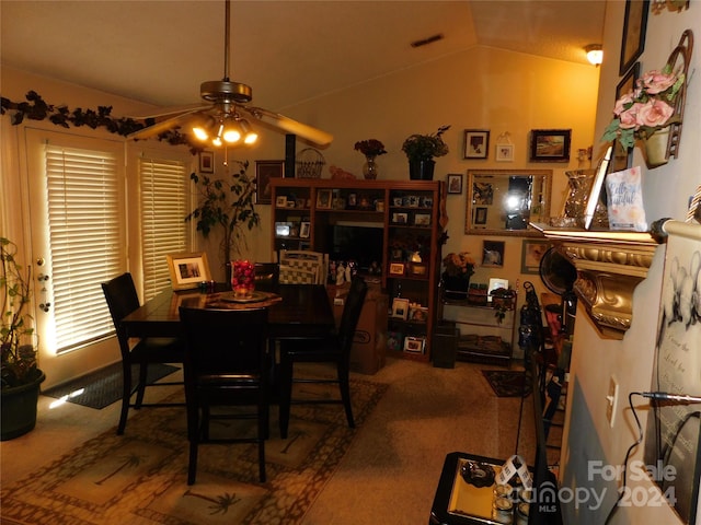 carpeted dining space featuring vaulted ceiling and ceiling fan