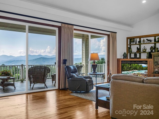 living room featuring lofted ceiling, a mountain view, and hardwood / wood-style flooring