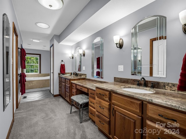 bathroom featuring a tub to relax in, vanity, and tile patterned floors