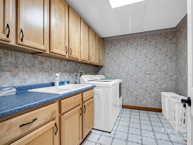 washroom with light tile patterned floors, sink, cabinets, and separate washer and dryer