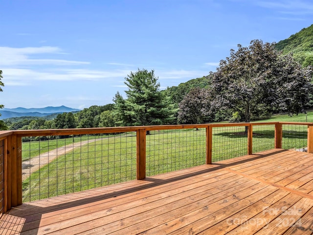 wooden terrace with a lawn and a mountain view