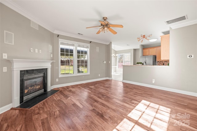 unfurnished living room featuring hardwood / wood-style floors, ceiling fan, and ornamental molding