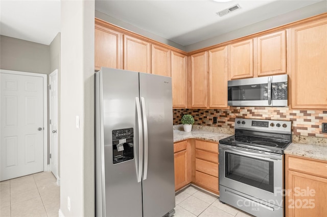 kitchen with decorative backsplash, light brown cabinetry, light stone counters, stainless steel appliances, and light tile patterned floors