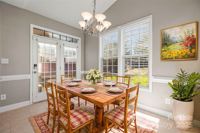 dining area featuring a wealth of natural light, light tile patterned floors, lofted ceiling, and an inviting chandelier