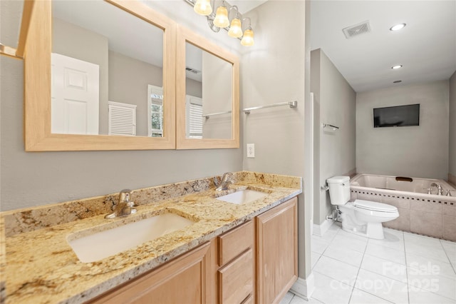 bathroom featuring tiled bath, tile patterned flooring, vanity, and toilet