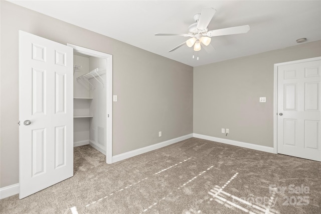 unfurnished bedroom featuring ceiling fan, a closet, a spacious closet, and light carpet