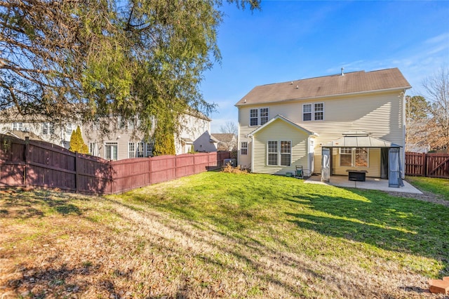 rear view of property with a gazebo, a patio area, and a lawn