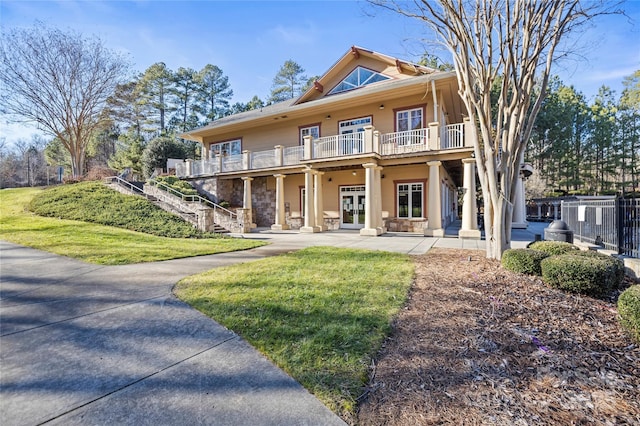 exterior space with french doors, a yard, and a balcony