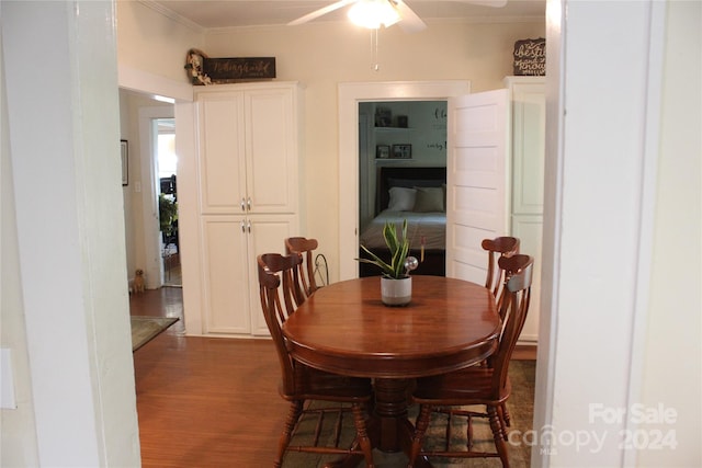 dining room featuring dark wood-type flooring, ceiling fan, and crown molding