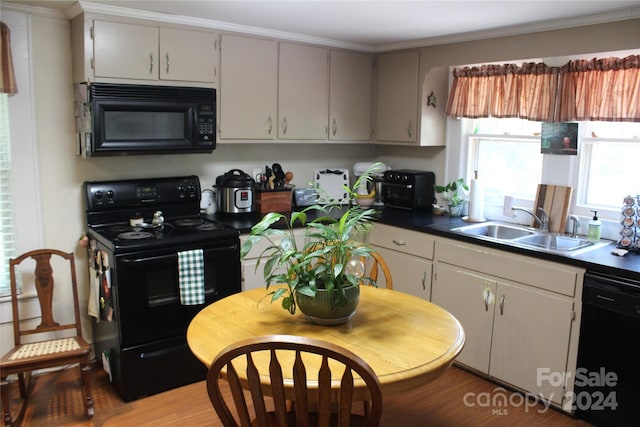 kitchen with hardwood / wood-style floors, black appliances, sink, gray cabinetry, and crown molding