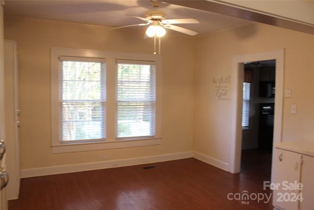 unfurnished room featuring dark wood-type flooring, ceiling fan, and crown molding