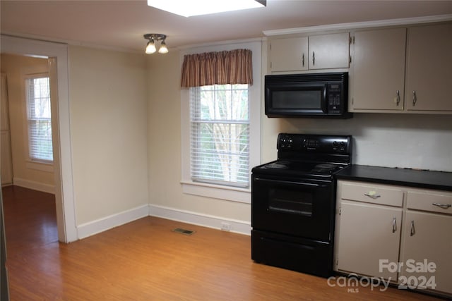 kitchen with light wood-type flooring, gray cabinetry, and black appliances