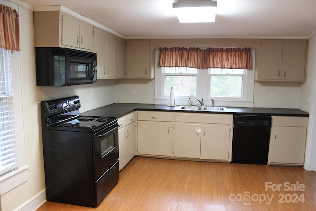 kitchen with black appliances, cream cabinets, crown molding, light wood-type flooring, and sink