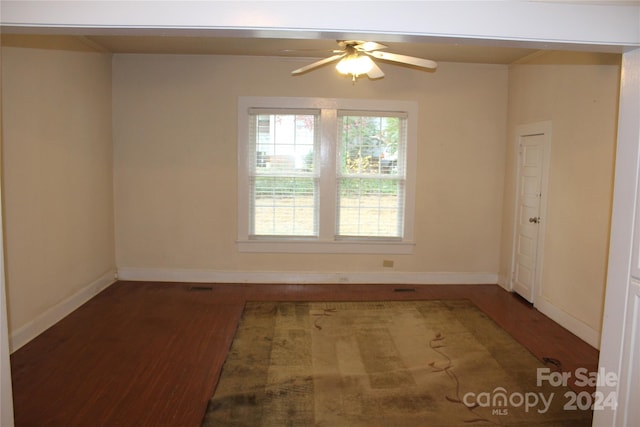 unfurnished room with dark wood-type flooring and ceiling fan