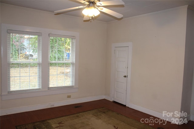 spare room featuring dark hardwood / wood-style flooring, ornamental molding, and ceiling fan