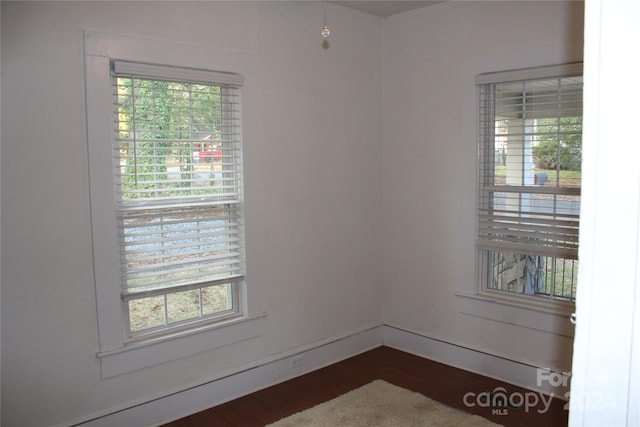 empty room with a healthy amount of sunlight and dark hardwood / wood-style floors