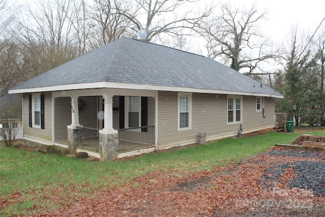 view of side of home with a yard and covered porch