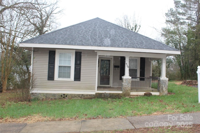 view of front of house with covered porch and a front lawn