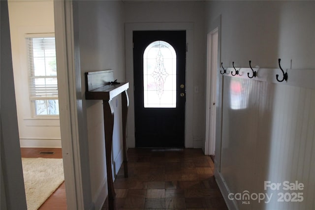 entryway with dark parquet flooring