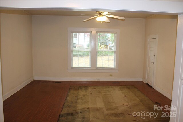 unfurnished room with dark hardwood / wood-style floors and ceiling fan