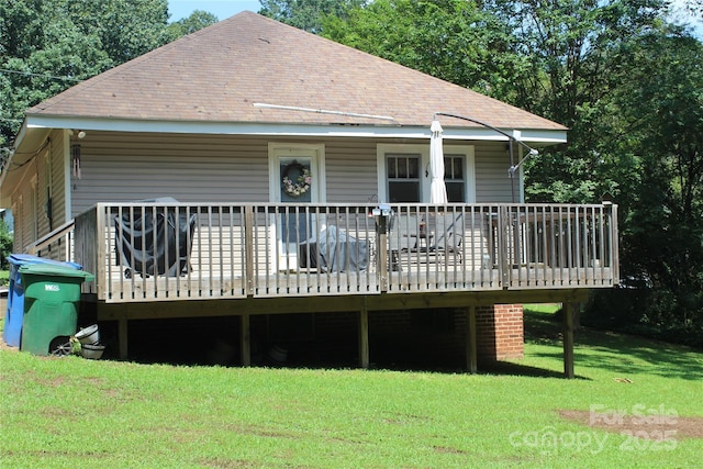 back of property featuring a wooden deck and a lawn