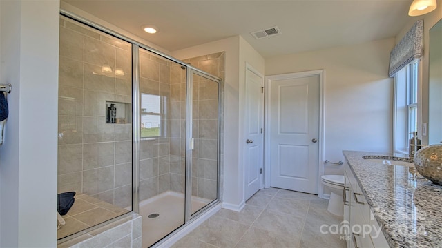 bathroom featuring tile patterned floors, vanity, an enclosed shower, and toilet