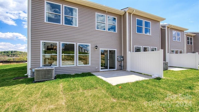 rear view of property with a patio, central air condition unit, and a lawn