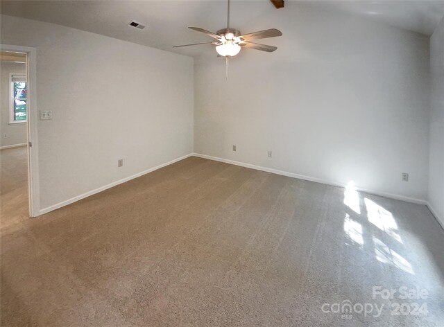 carpeted spare room featuring ceiling fan and vaulted ceiling