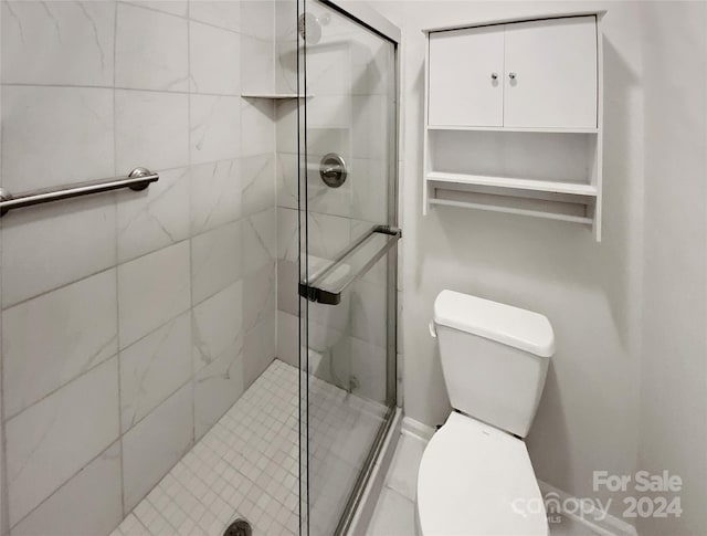 bathroom featuring an enclosed shower and toilet