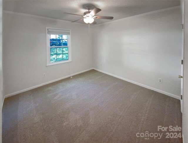 carpeted spare room featuring ceiling fan and a textured ceiling