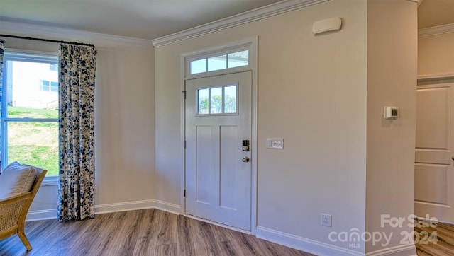 entryway with ornamental molding, plenty of natural light, and light wood-type flooring