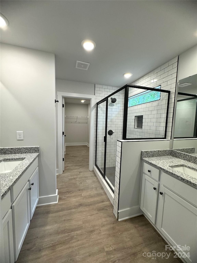 bathroom with vanity, hardwood / wood-style flooring, and walk in shower