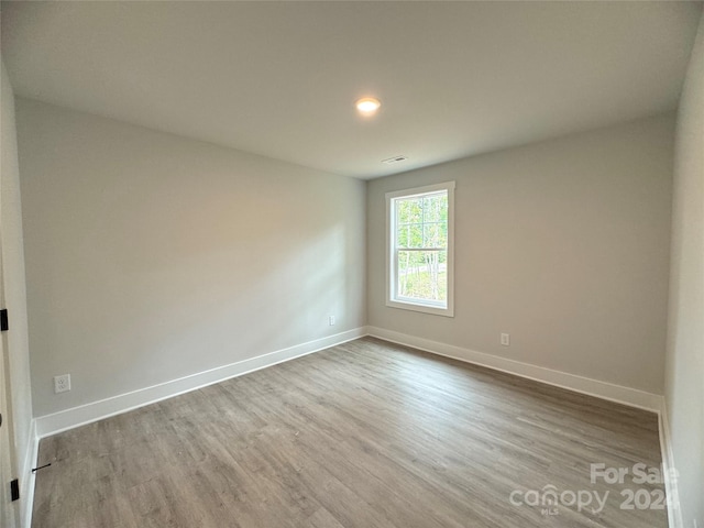 empty room with hardwood / wood-style flooring