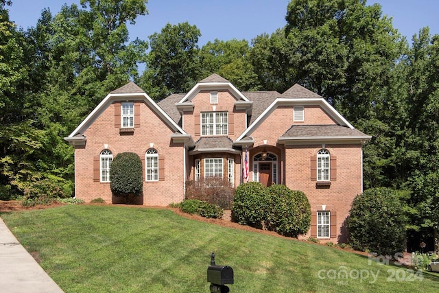 view of front of house with a front lawn and brick siding