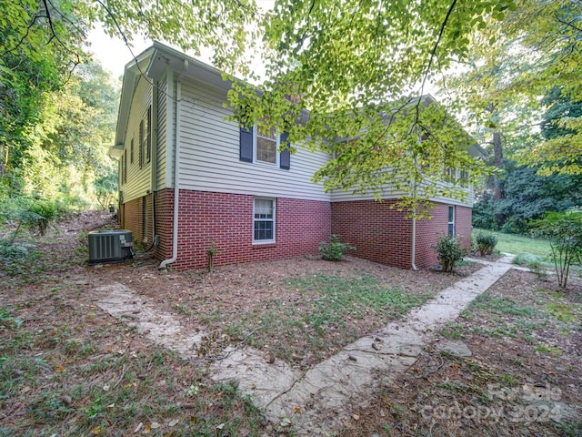 rear view of house featuring central AC unit