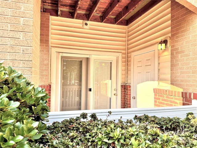 doorway to property featuring brick siding