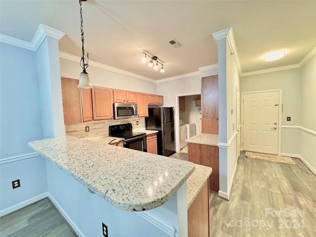 kitchen with washing machine and clothes dryer, tasteful backsplash, light wood-style floors, a peninsula, and black appliances